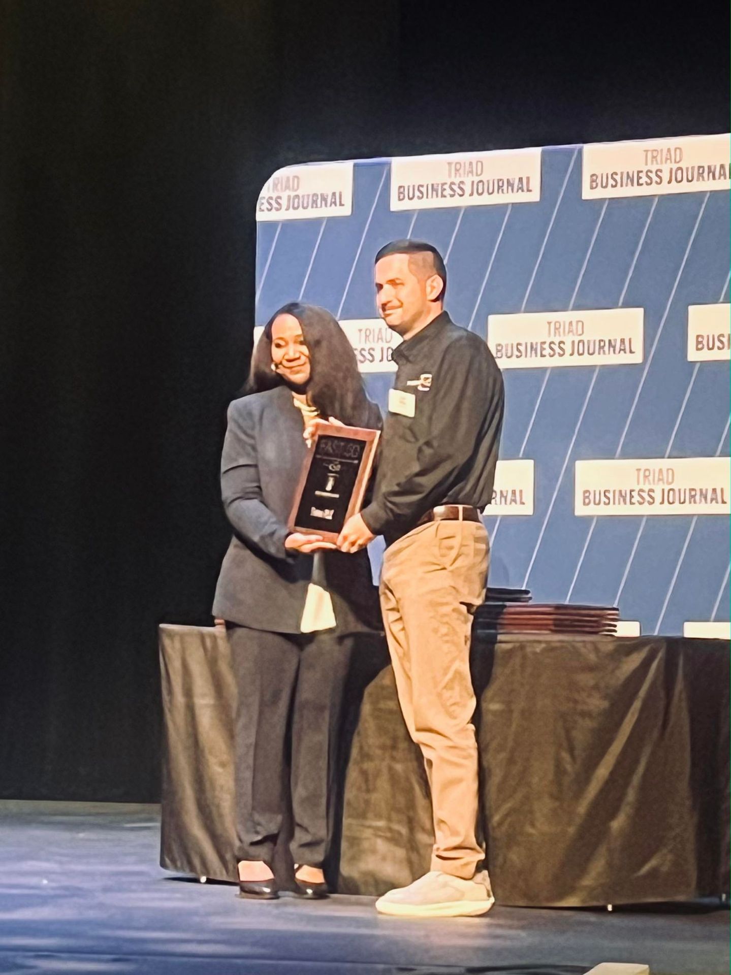 Logan Tedder accepting the 2026 Triad Business Journal Fast 50 award on stage