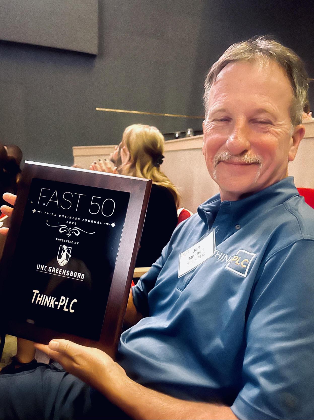 Jeff Mitchell holding the Fast 50 plaque
